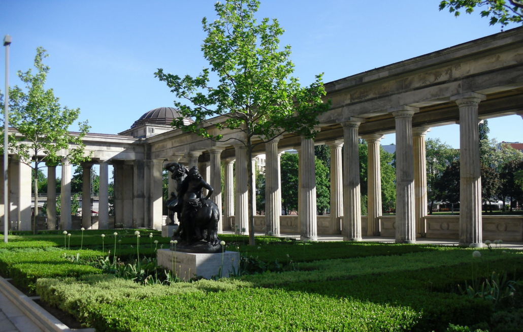 Grüne Anpflanzungen mit Statue vor Kollonaden durch guten Gartenservice auf der Museumsinsel Berlin